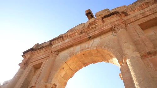 Lumière du coucher de soleil baignant l'arche des anciennes ruines romaines de Sbeitla en Tunisie, ciel clair