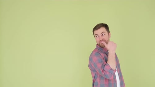 Ein Mann schaut auf olivfarbenem Hintergrund in die Kamera. Er wirbt für ein bestimmtes Produkt