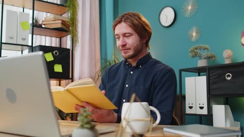 Business Man Reading Book Turning Pages Smiling Enjoying Literature Taking a Rest Relaxing at Office