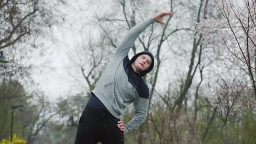 Young Adult Stretching Arms in Urban Park