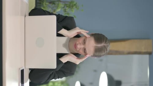 Woman Massages Temples While Working