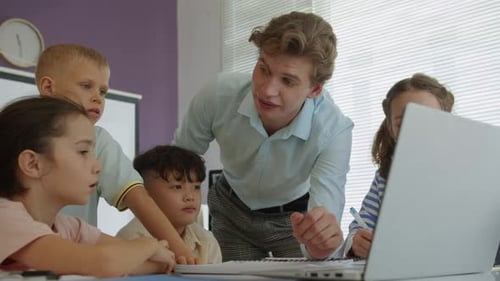 Tutor and Kids Doing Group Task on Laptop during Programming Class