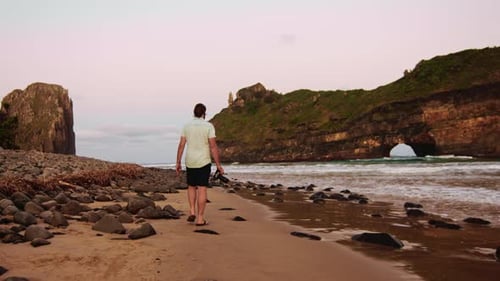 Of a Traveling Professional Photographer Man Walking on Pebble Beach And