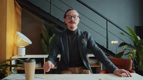 Businessman Sitting in Office and Speaking at Camera during Web Conference