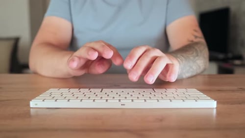 Close up male tattooed hands typing on laptop keyboard. Software, online education, apps