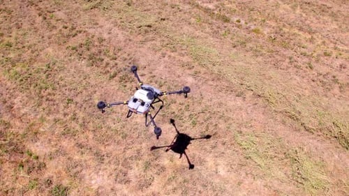 Flying A Single Agriculture Quadcopter Drone Over Farm Field. - Overhead Shot