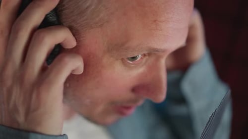Closeup of Man Adjusting Black Studio Headphones in Music Production Session