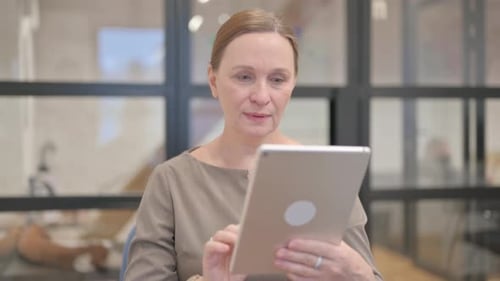 Excited Woman Using Tablet in Modern Office