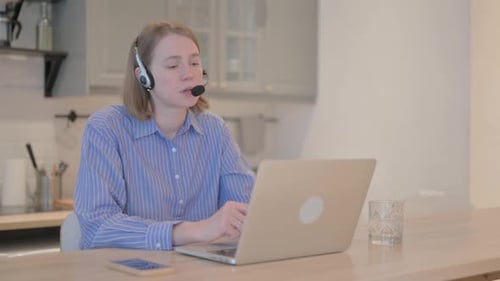 Young Woman with Headset Talking with Customers Online in Call Center