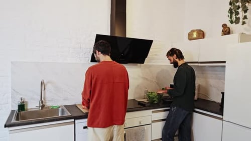 Young Adults Making a Salad in Bright Kitchen