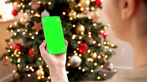 Christmas, Technology and Holidays Concept - Smiling Woman with Chromakey Green Screen