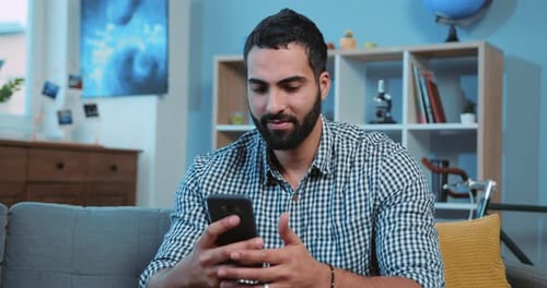 Close Up Attractive Young Man Use Phone Smiling Feel Happy Sit on Sofa Home Portrait Smartphone