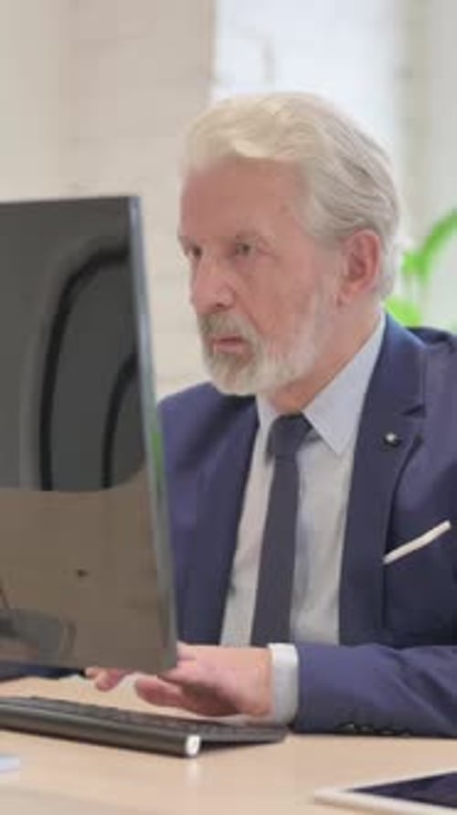 Senior Man Working on Computer at Office