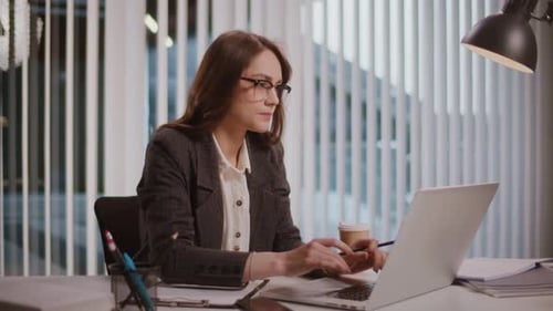 Focused Woman Working at Desk in Bright Office