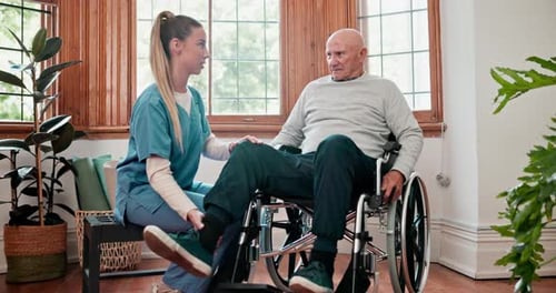 Senior Man in Wheelchair Receives Assistance from Nurse
