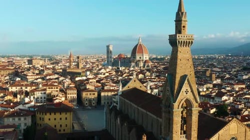 Flying over rooftops and spires of Florence, Italy. Sunrise