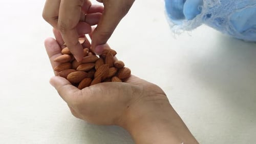Top View of Women Hand Holding Almond Nuts