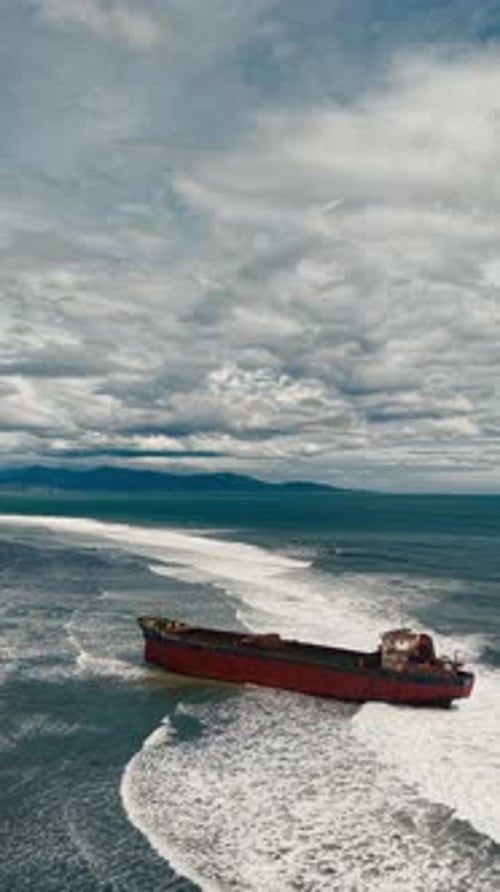 Aerial view, top view of old rusty stranded logistics ship on the beach