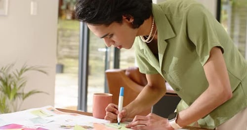 Pendant le brainstorming, divers collègues placent des notes autocollantes et écrivent sur un panneau d'affichage à la maison