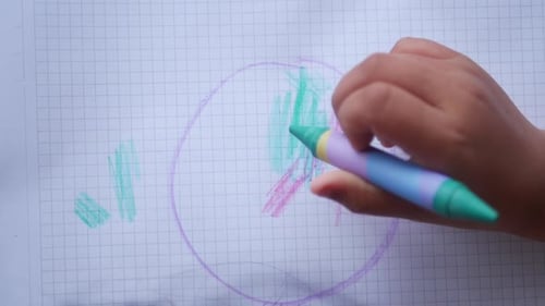 Child Enjoys Creative Drawing with Colorful Markers in a Sketchbook