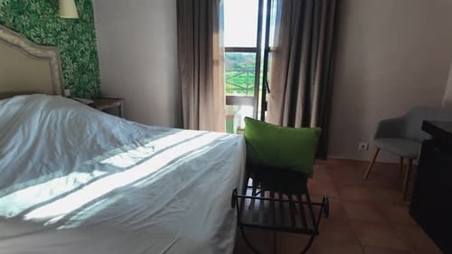 Slow-motion sunny bedroom with nature view through window