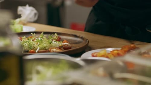 Chef plating fresh salad in restaurant kitchen