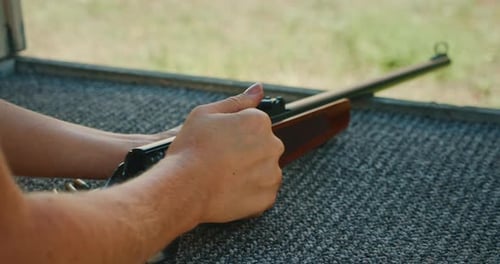 Adult Loads Ammunition Into Bolt Action Rifle