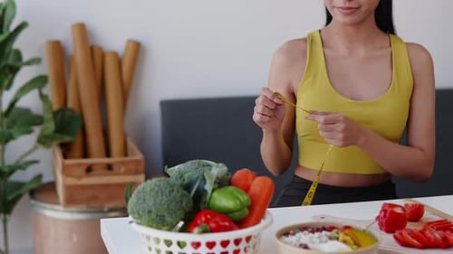 Young Woman Measuring Waist with Vegetables Nearby