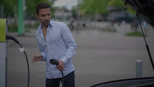 A Person Charging an Electric Vehicle at a Dedicated Station Designed for That Purpose