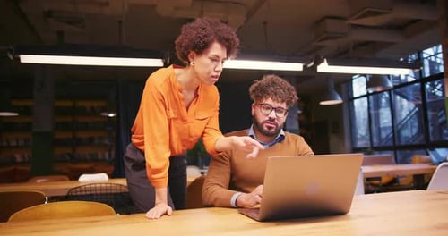 Colleagues Collaborating on Laptop in Modern Office Coworking Space Together Working