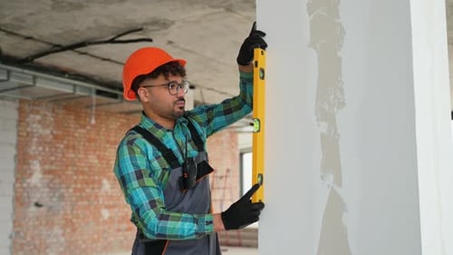 Construction Worker Using Level in Renovated Building
