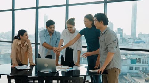 Enthusiastic Team Celebrating Success with Hands Together Indoors