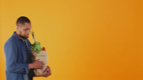 Young Adult Holding Bag of Fresh Vegetables