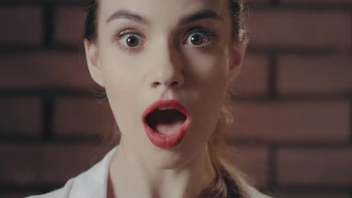 Surprised young woman looks shocked close up