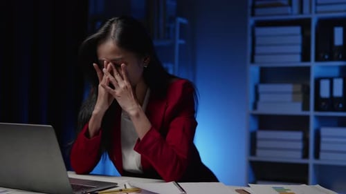Businesswoman seriously stressed working overtime headache and eye ache due to office syndrome