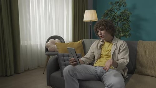 Young Adult Video Call on Tablet at Home