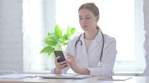 Lady Doctor Using Smartphone While Sitting in Clinic