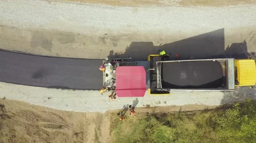 Aerial View of New Road Construction with Workers and Asphalt Laying Machinery at Work