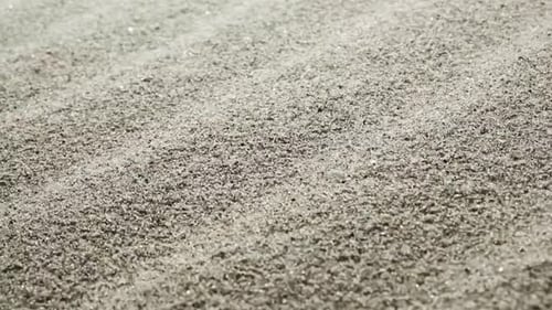 A Slow Motion Close Up View of Fine Shimmering Sand Grains Reflecting Light Creating a Sparkling