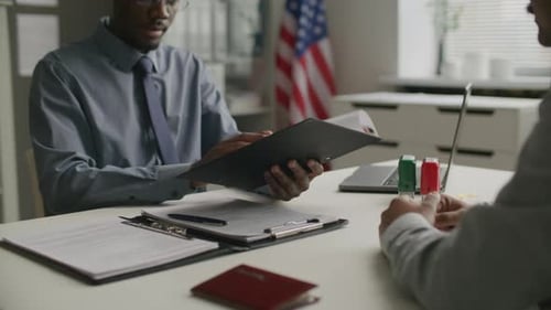 Consular Officer Reviewing Documents and Conducting Visa Interview at US Embassy
