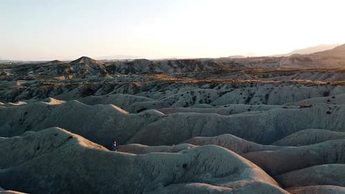 Landscape of dunes desert drone point of view of woman traveling through Mahoya in Spain against sun