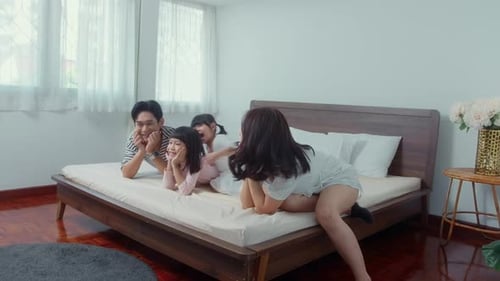 Happy Family Playing Together in Bedroom