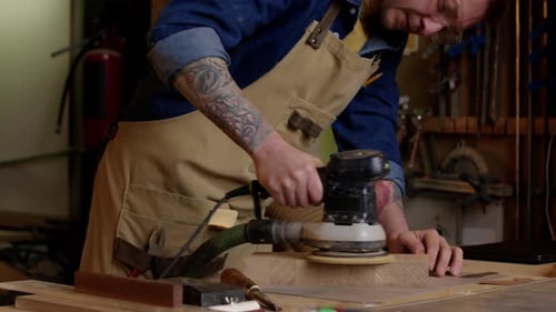 Carpenter Using Angle Grinder while Doing Woodwork in Workshop