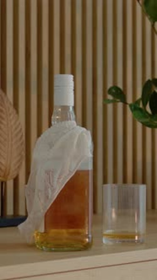 Vertical video Office desk setting with liquor and casual clothing left behind in the room