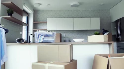 Boîtes de déménagement et porte-vêtements sur le sol dans une nouvelle maison