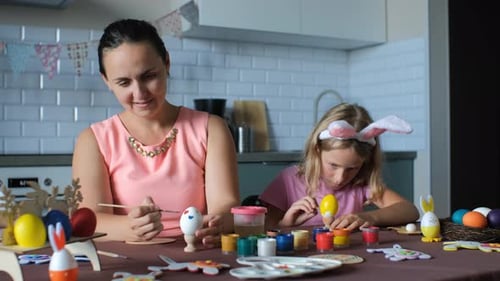 Mother and Daughter Decorating Colorful Easter Eggs at Home