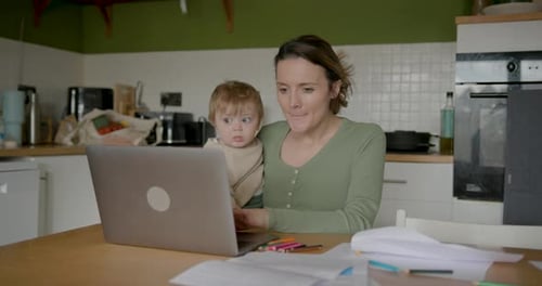 Woman and Baby Using Laptop in Kitchen