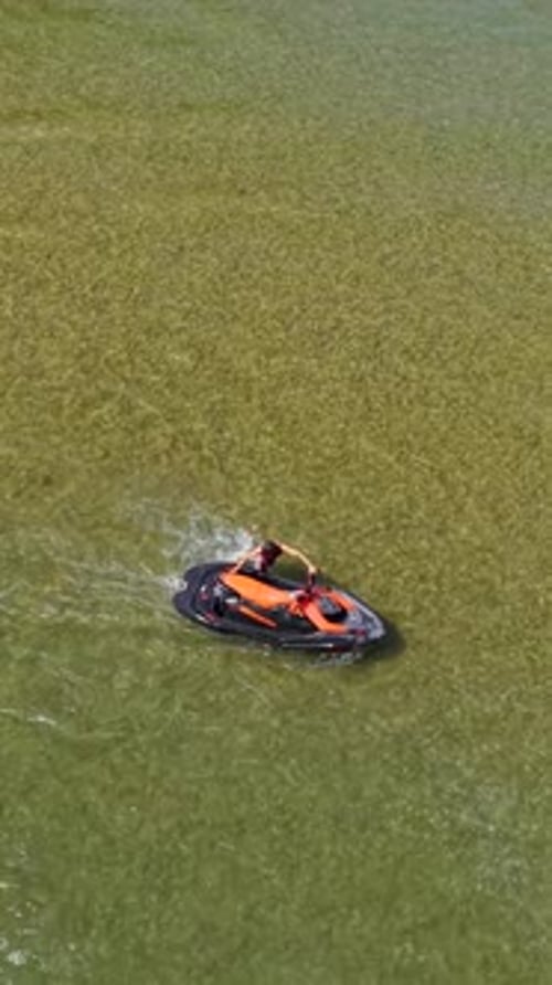 Vertikales Video von oben nach unten eines Wasserfahrzeugs, das auf See rast
