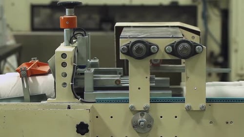 Toilettenpapierrollen, die sich durch die Verpackungsmaschine bewegen — 4K