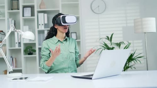 Woman with VR Headset Gesturing in Bright Office